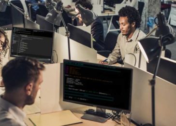 Homens e mulheres trabalhando na frente de vários computadores, usados para blockchain