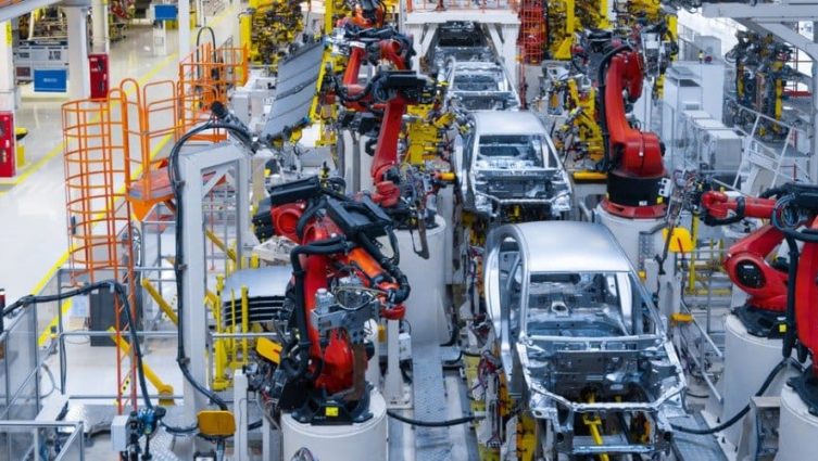 Linha de produção automotiva com robôs auxiliando na produção de veículos